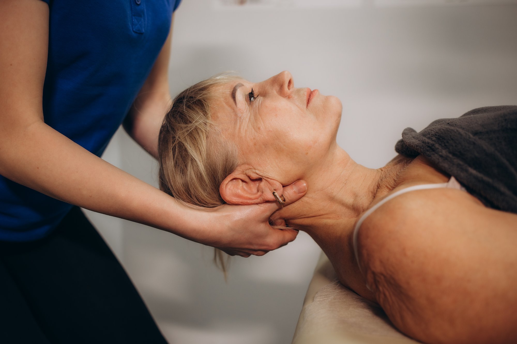 a-rehabilitator-massages-the-neck-of-an-elderly-wo-2025-03-16-22-24-48-utc